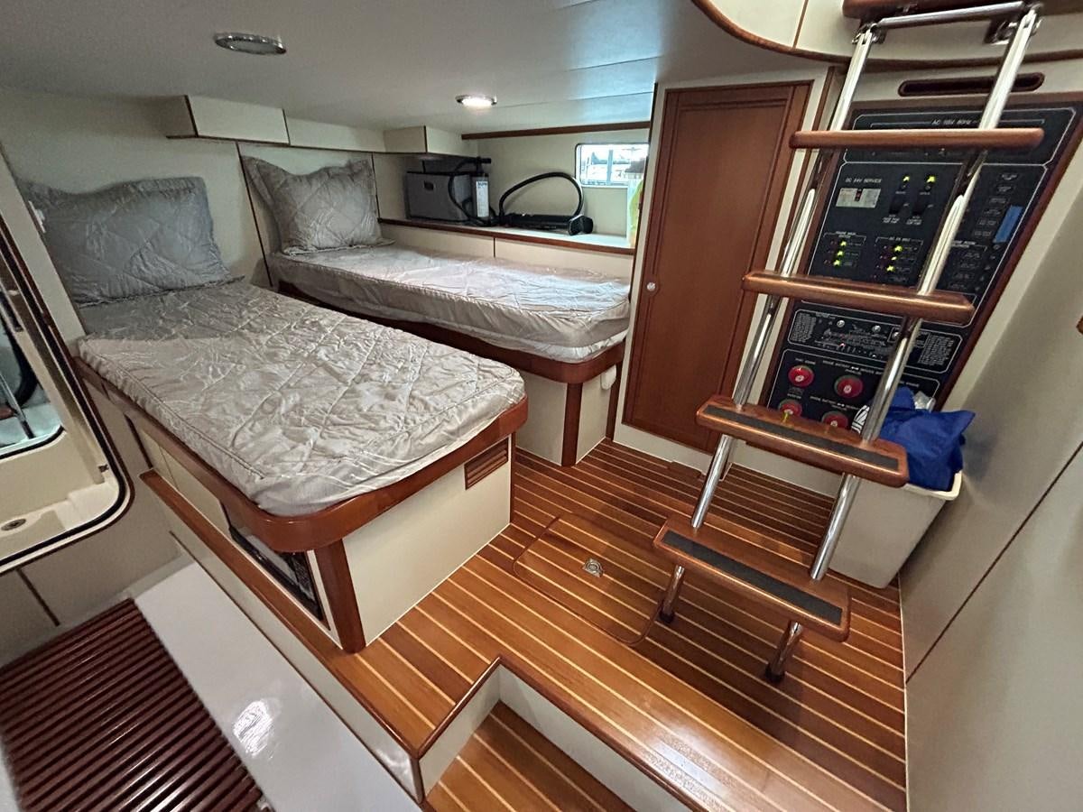 a bedroom with a bed and a dresser aboard NOVIA II Yacht for Sale
