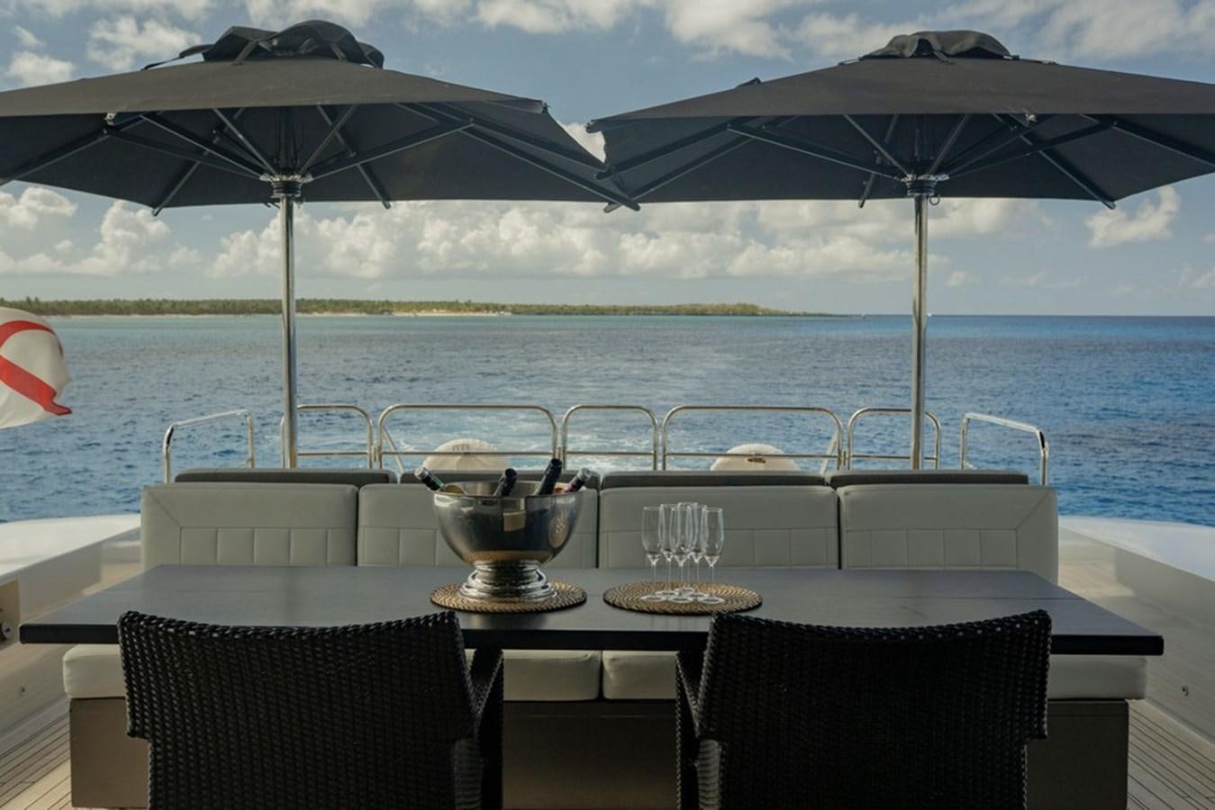 a table with chairs and umbrellas on it by the water aboard LEOPARD 31 OPEN Yacht for Sale