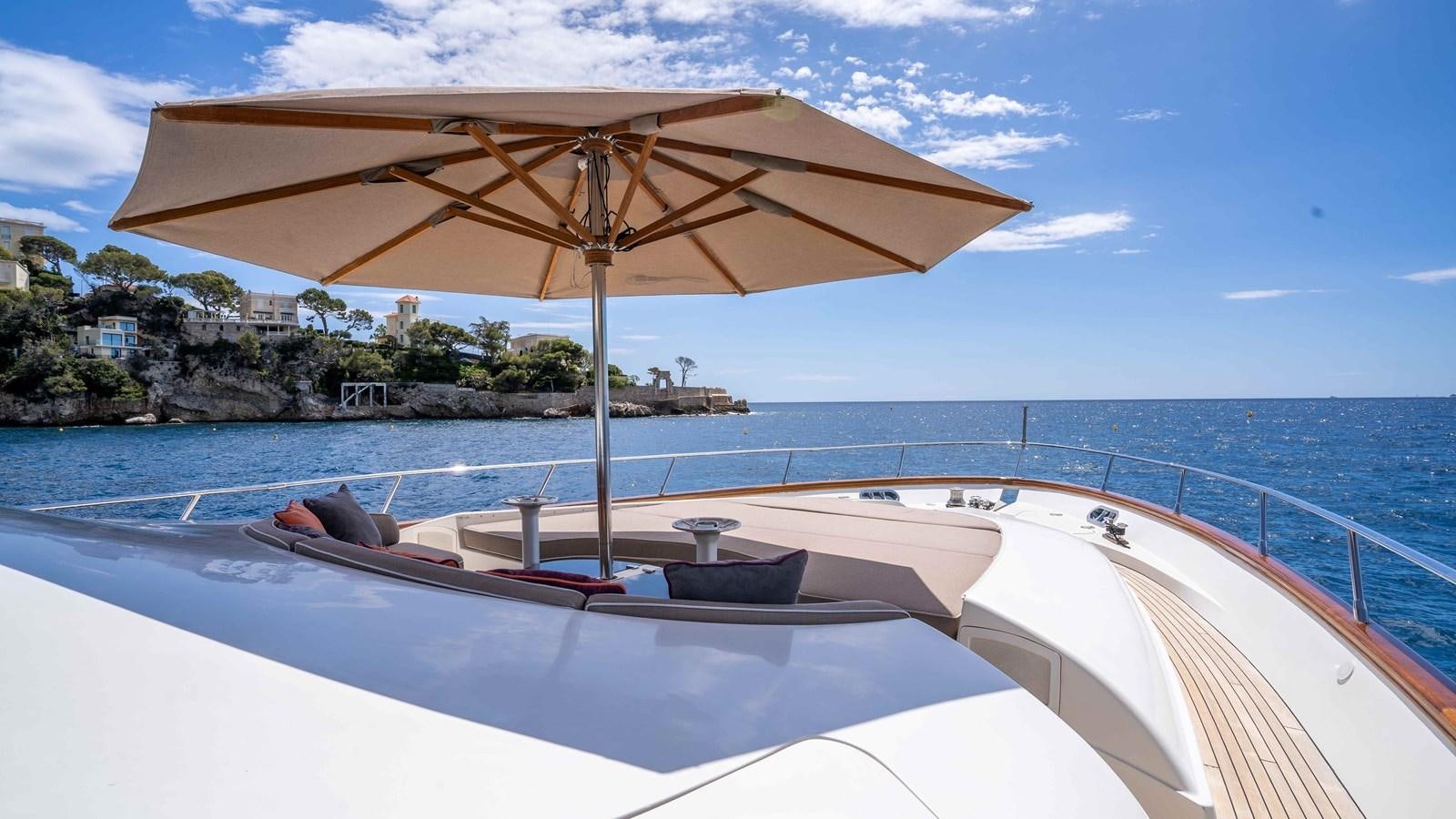 a person lying on a lounge chair under an umbrella on a boat aboard ELEGANCE OF CANNES Yacht for Sale