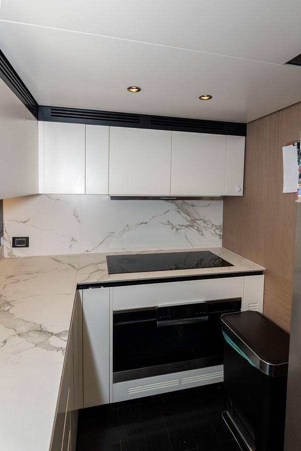 a kitchen with white cabinets aboard CLOUDY BAY Yacht for Sale