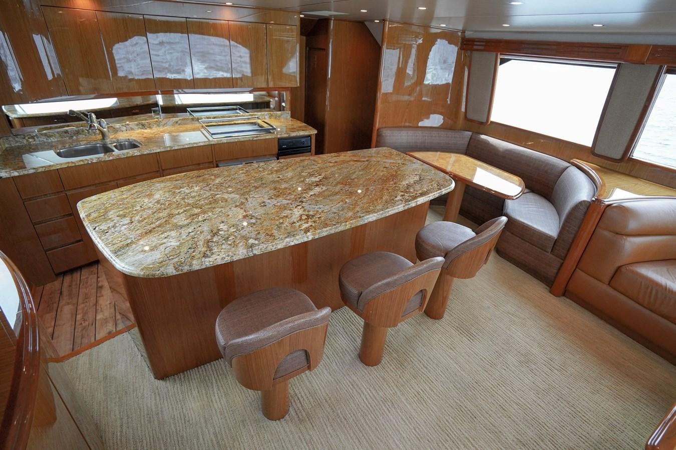 a large kitchen with a bar and stools aboard BENEDETTA Yacht for Sale