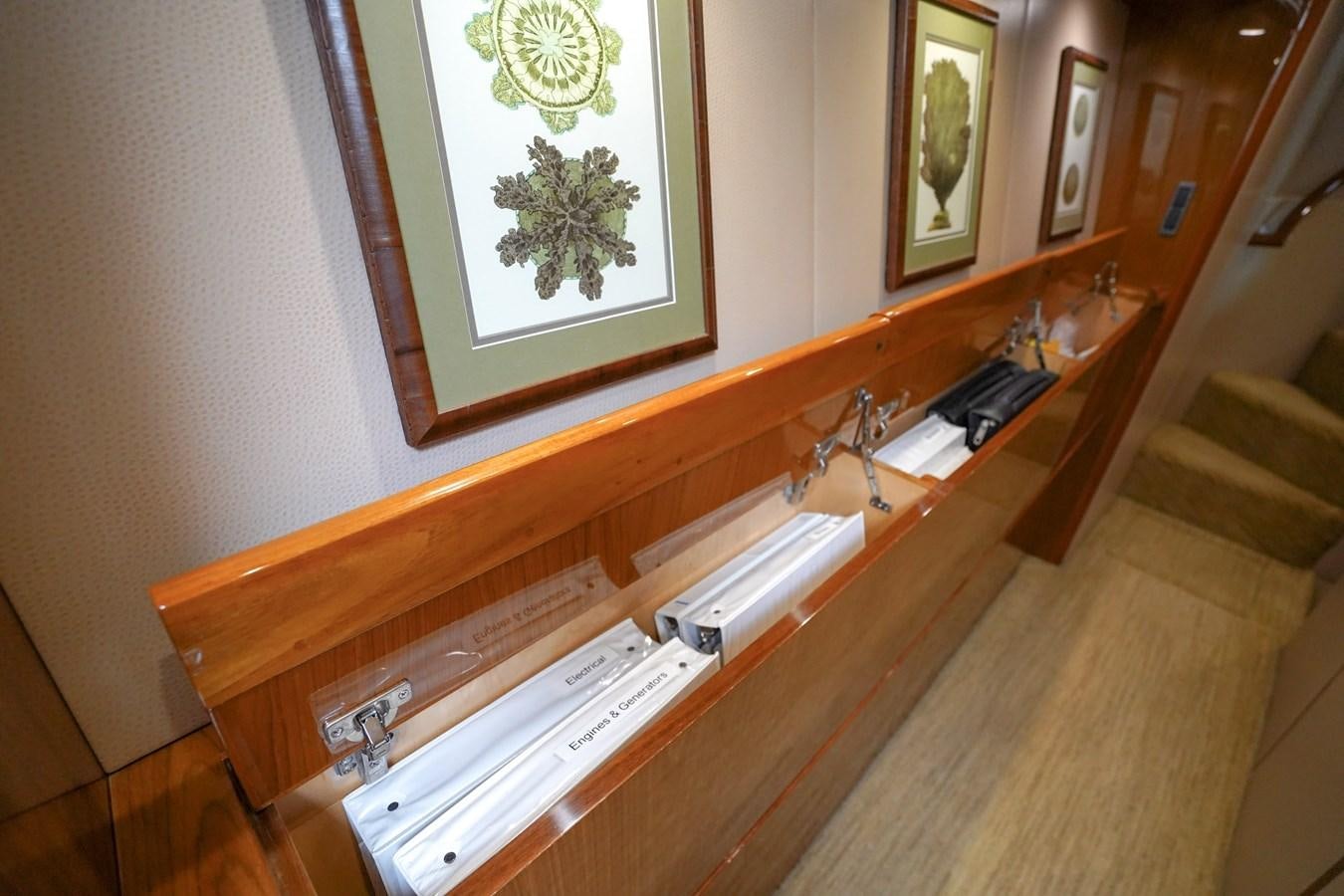 a wooden table with a book and a picture on it aboard BENEDETTA Yacht for Sale