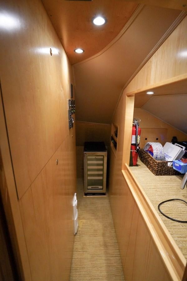a hallway with a wood door and a shelf with objects on it aboard BENEDETTA Yacht for Sale