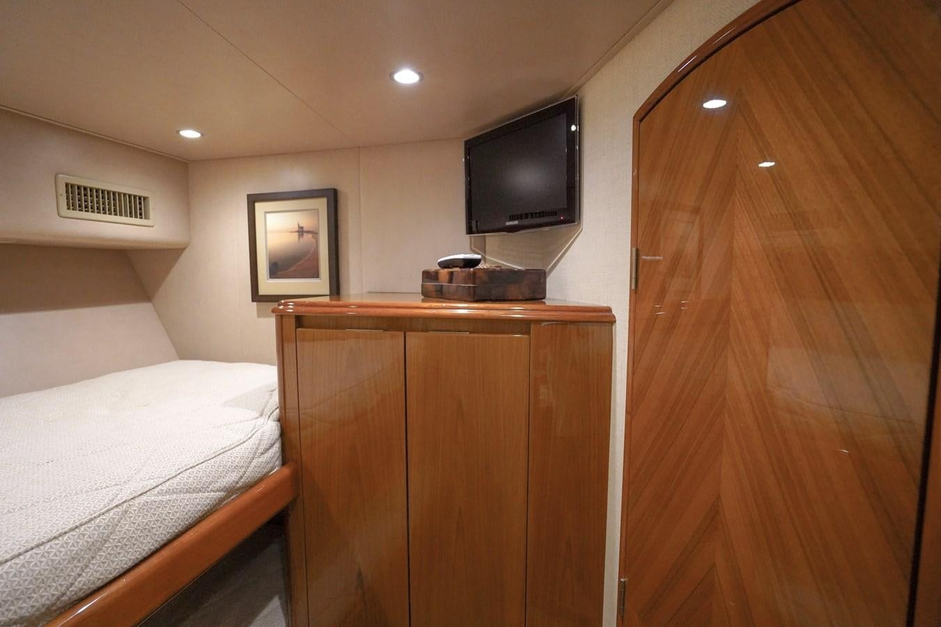 a bedroom with a wood cabinet and tv aboard BENEDETTA Yacht for Sale