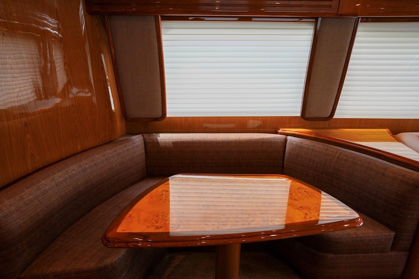 a wooden bench with a table in front of a window aboard BENEDETTA Yacht for Sale