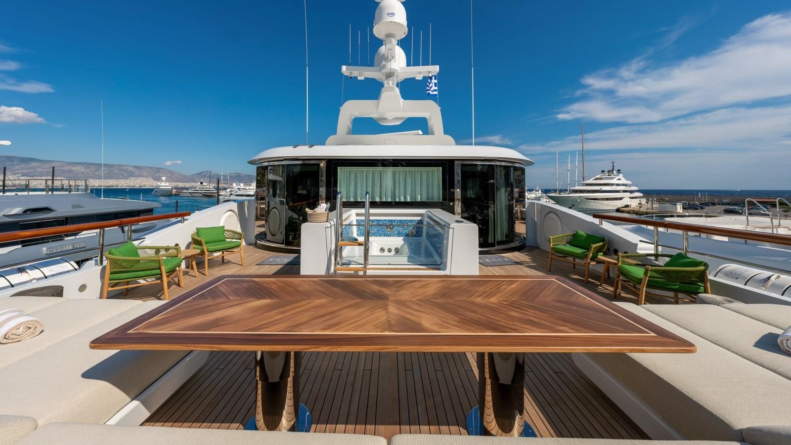 a deck with a table and chairs on it aboard AELIA Yacht for Sale