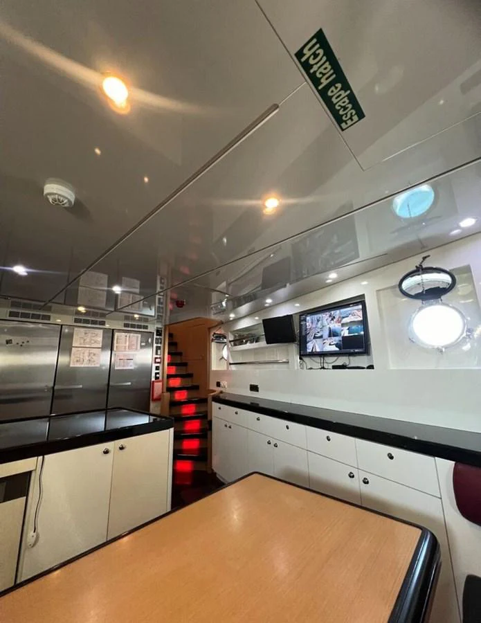 a kitchen with a counter and a tv on the wall aboard WHISPER Yacht for Sale