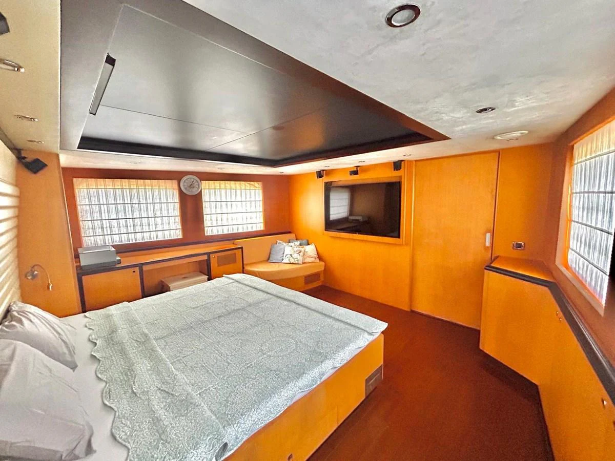 a bedroom with a bed and a tv aboard WHISPER Yacht for Sale
