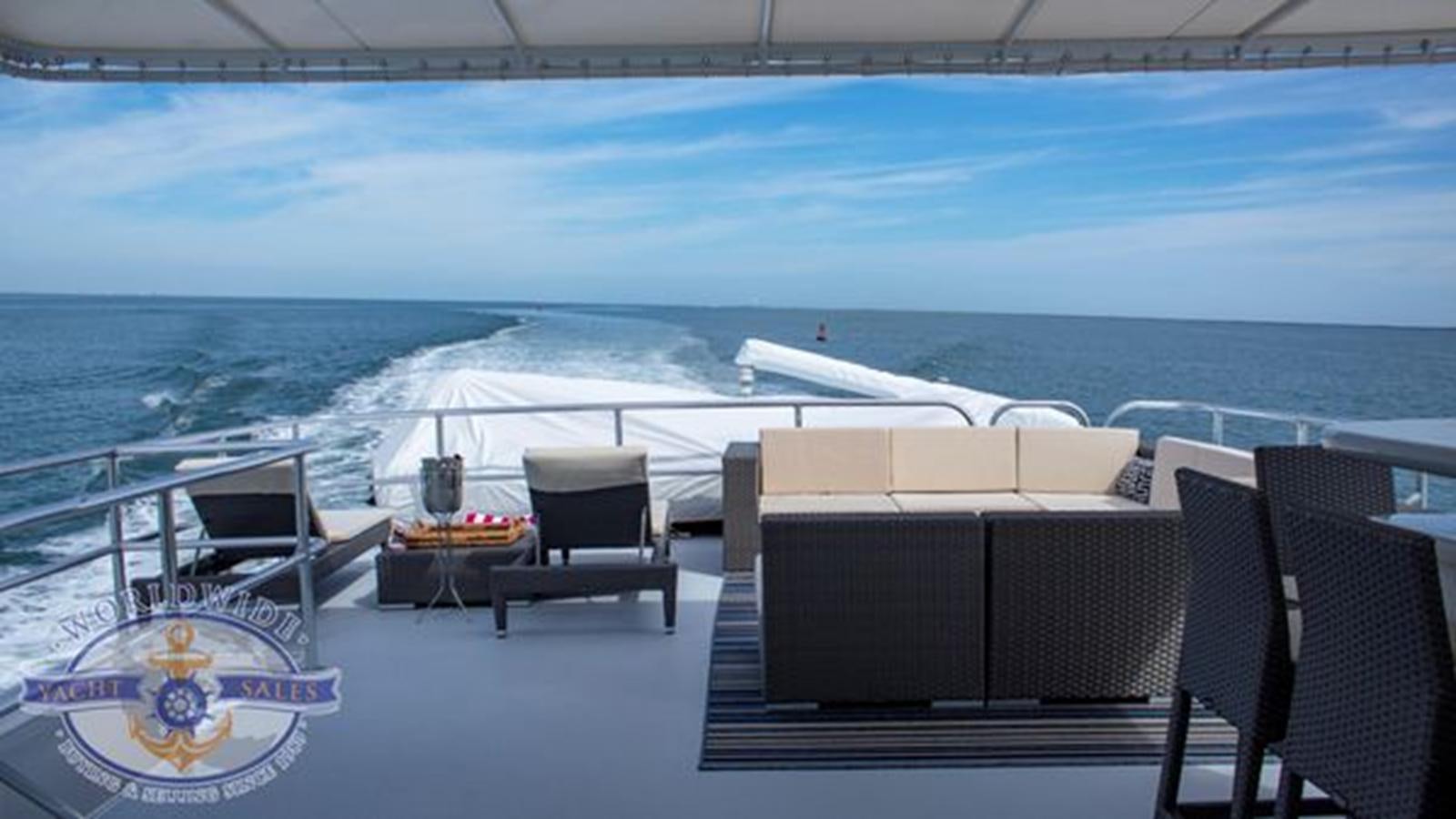 a patio with chairs and tables on it next to a body of water aboard ISLAND SOUL Yacht for Sale