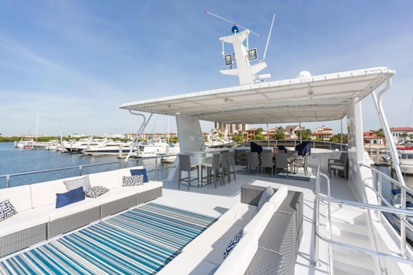 a deck with a deck and a large building with a white tower and blue sky aboard ISLAND SOUL Yacht for Sale