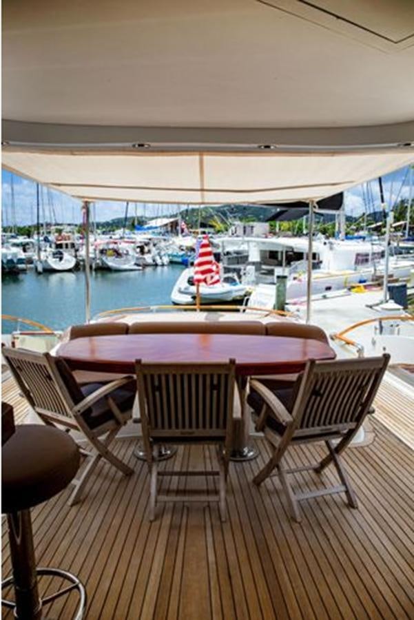 a table and chairs on a deck overlooking a marina aboard LOVIN LIFE Yacht for Sale