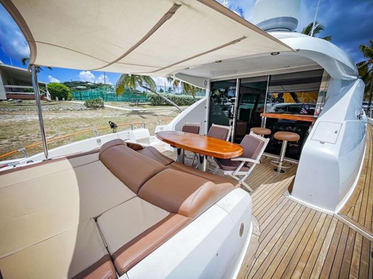 a lounge area with a table and chairs and a large white tent aboard LOVIN LIFE Yacht for Sale