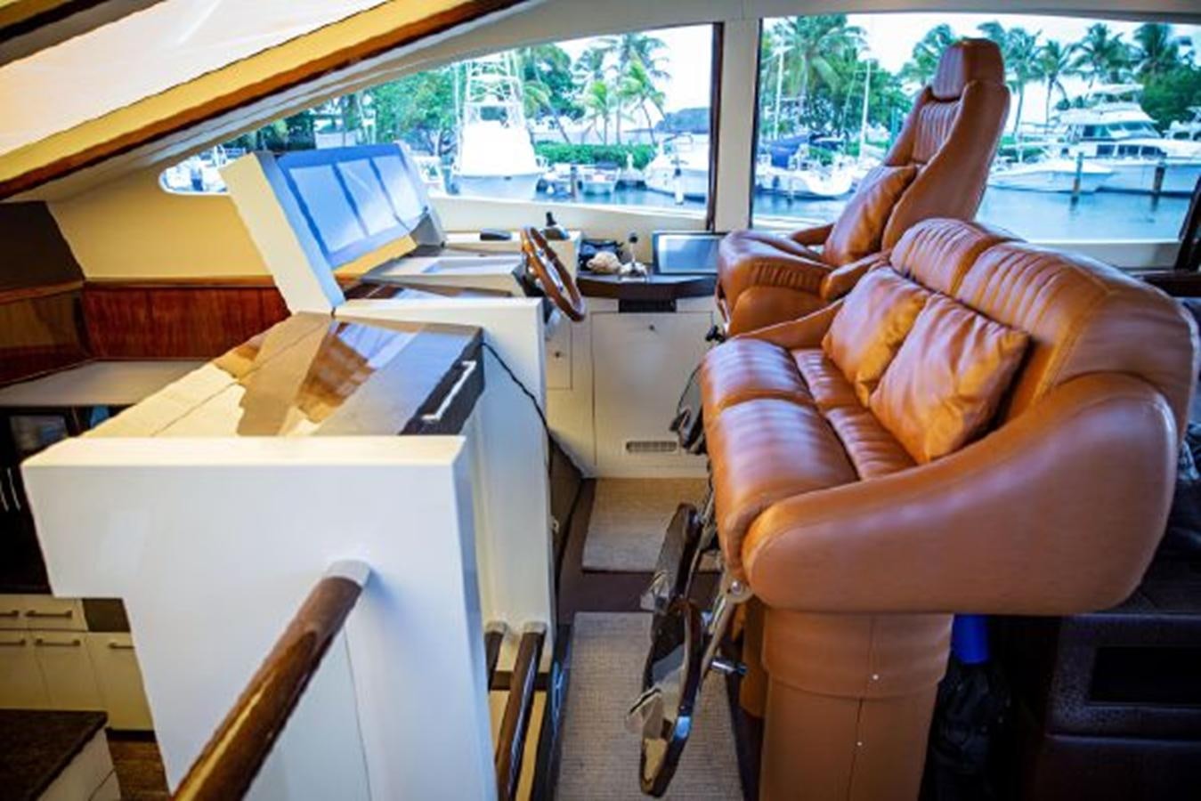 a person's legs on a chair in a room with a window aboard LOVIN LIFE Yacht for Sale