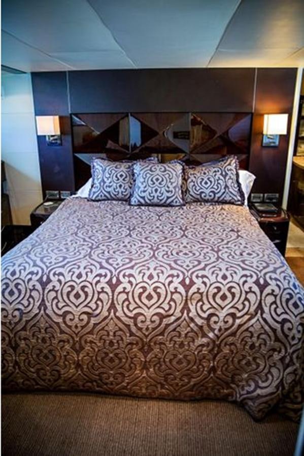 a bed with a large white comforter and pillows aboard LOVIN LIFE Yacht for Sale