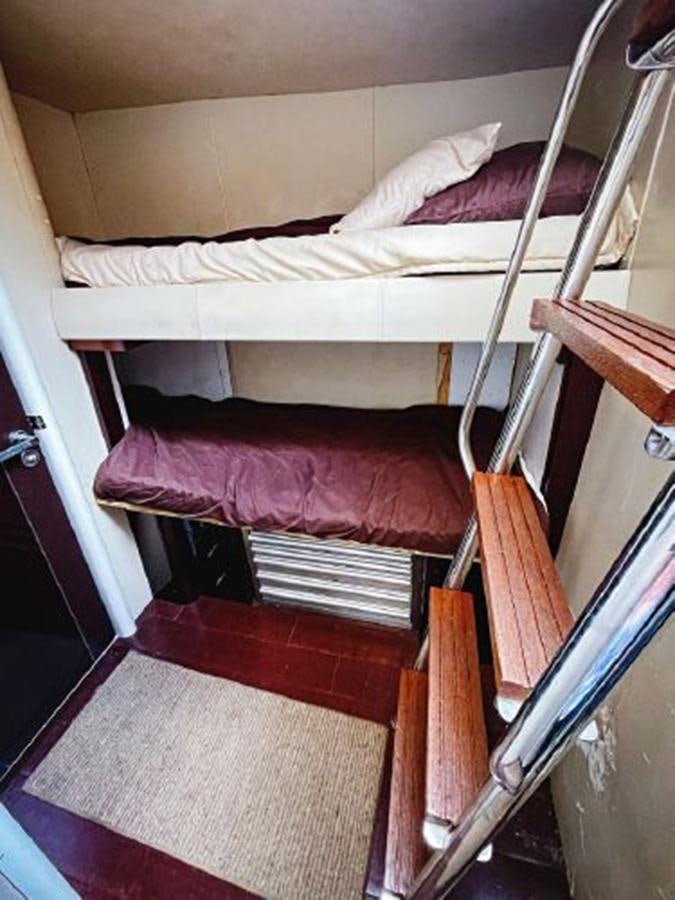 a bed with a white sheet and pink pillows aboard LOVIN LIFE Yacht for Sale