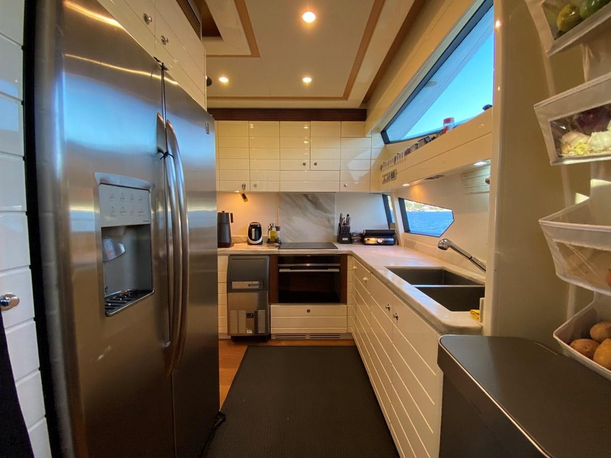 a kitchen with a stainless steel refrigerator aboard ADF Yacht for Sale