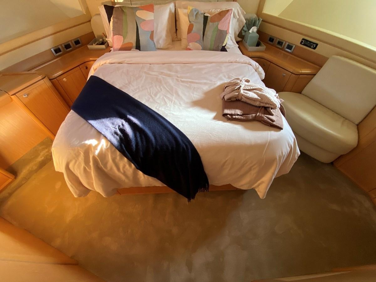 a bed with a blue blanket aboard ADF Yacht for Sale