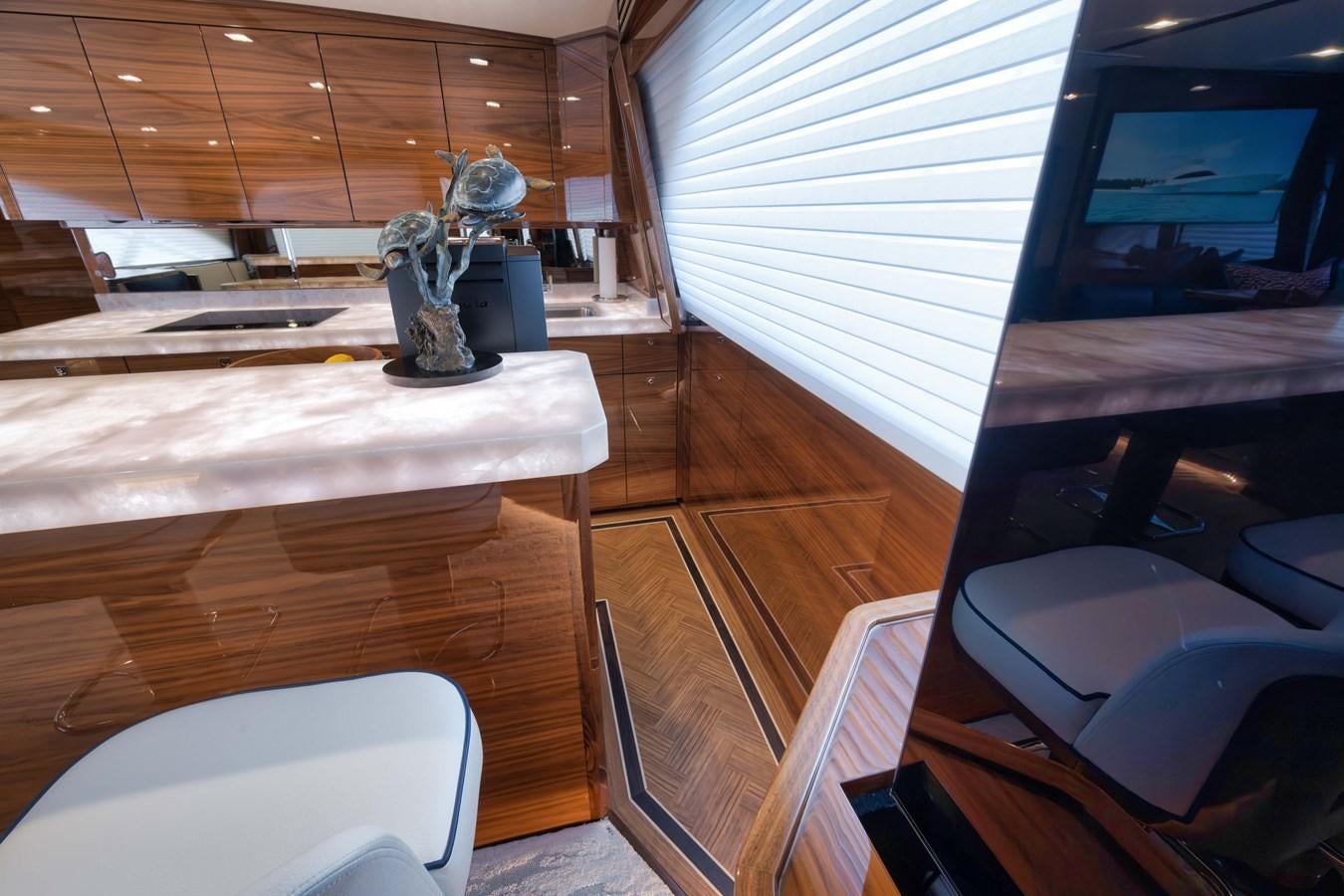 a room with a wood floor and a desk with a chair and a statue on it aboard MISS CARRIE Yacht for Sale