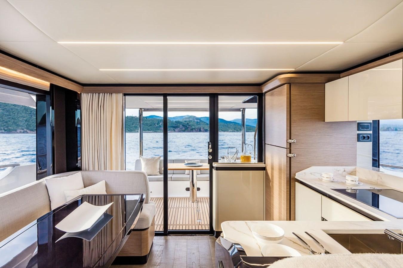 a room with a table chairs and a window aboard NAVETTA 75 Yacht for Sale