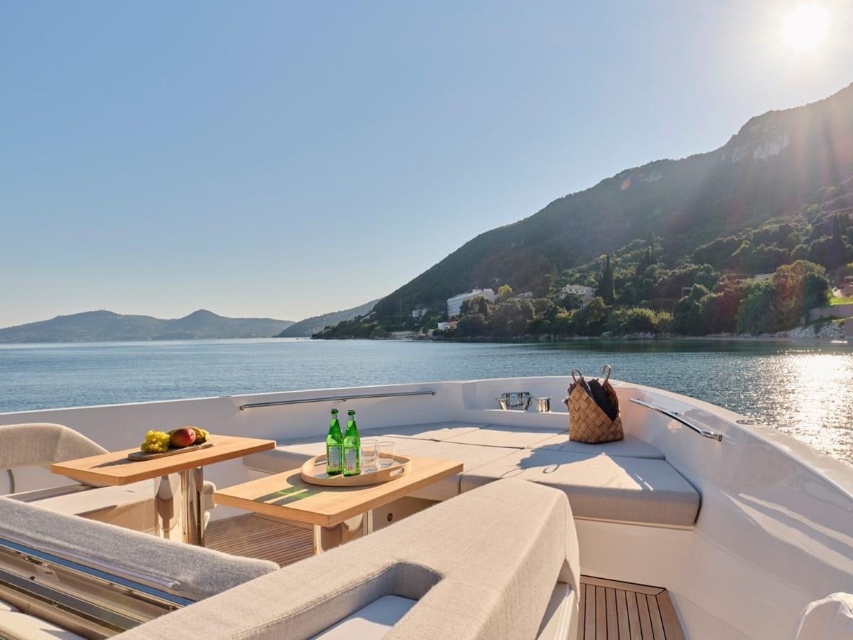 a table and chairs on a deck overlooking a body of water aboard 2022 SANLORENZO SX76 #72 Yacht for Sale