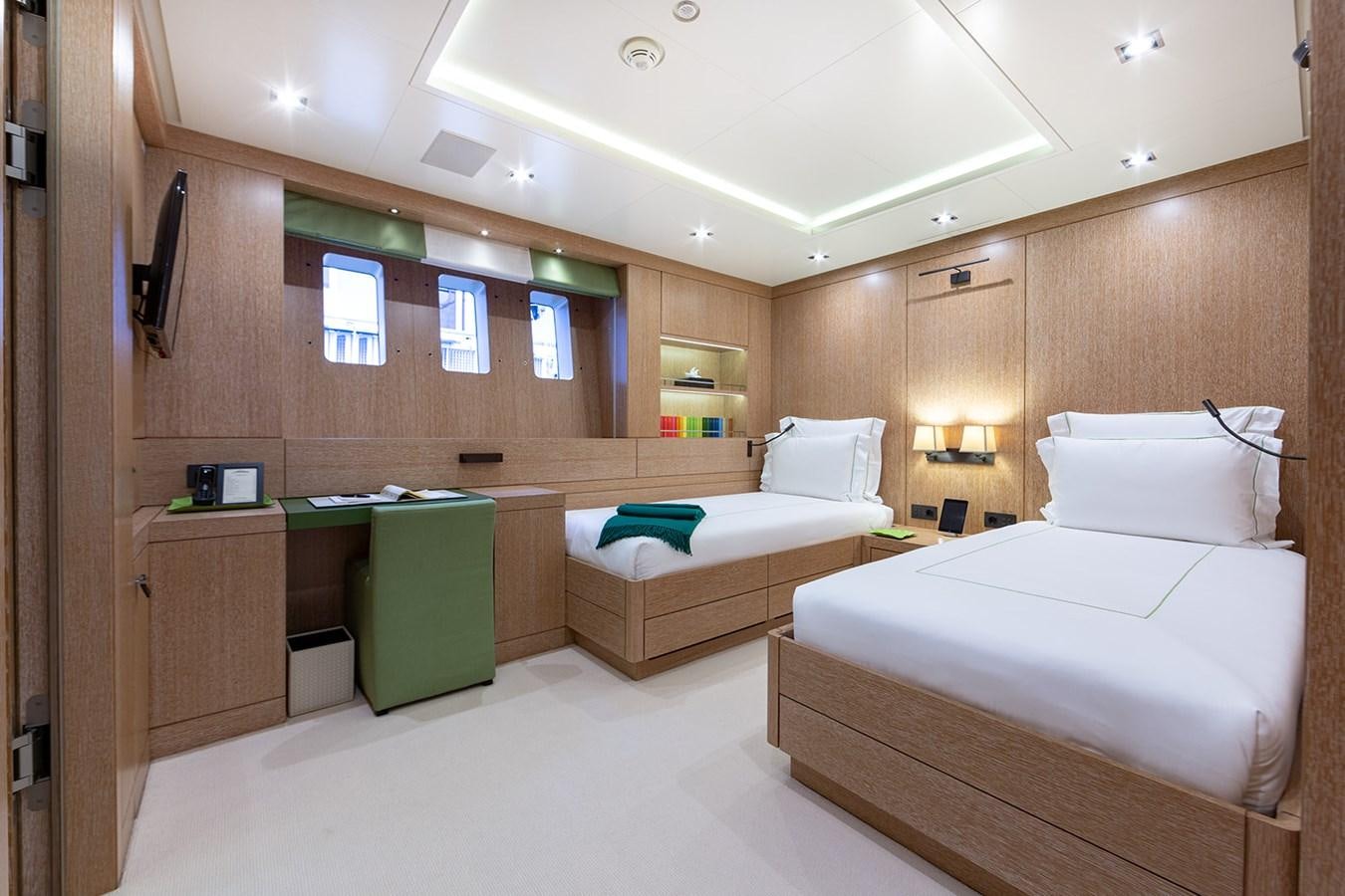 a room with beds and a desk aboard BELONGERS Yacht for Sale