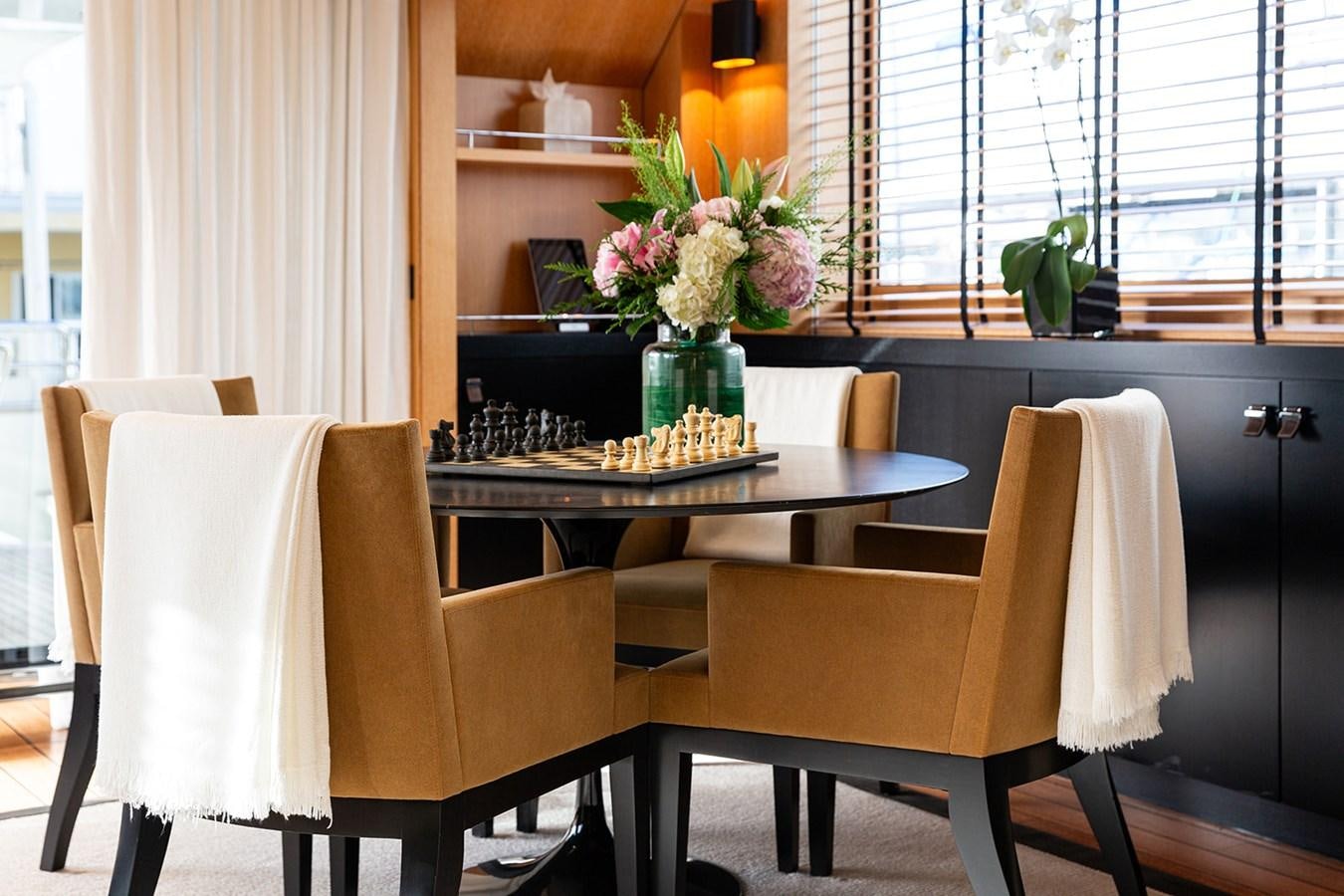 a table with chairs and a vase of flowers on it aboard BELONGERS Yacht for Sale