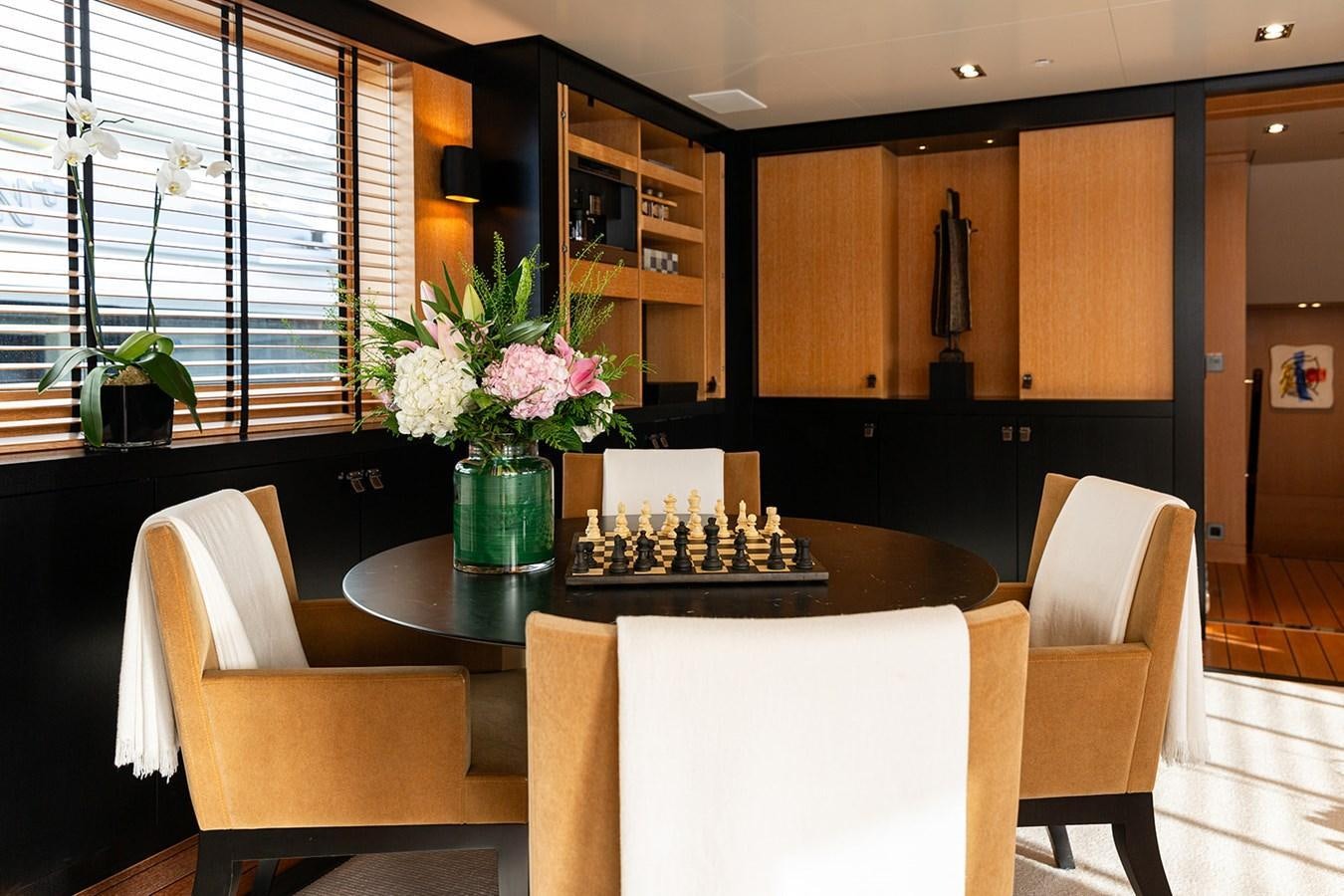 a piano in a room with chairs and a table with a piano aboard BELONGERS Yacht for Sale