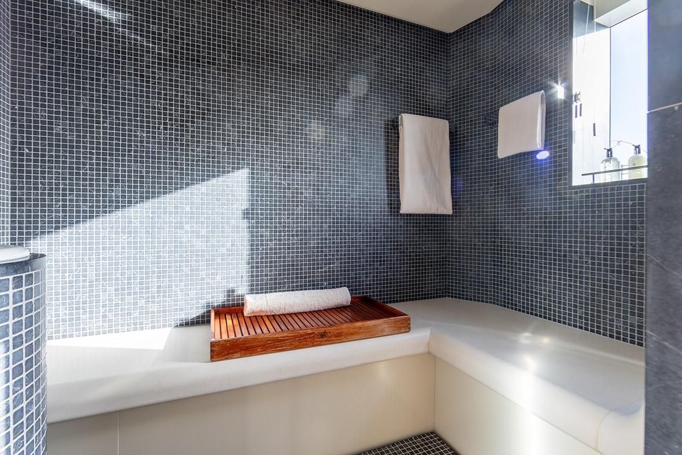 a bathroom with a bathtub and sinks aboard BELONGERS Yacht for Sale