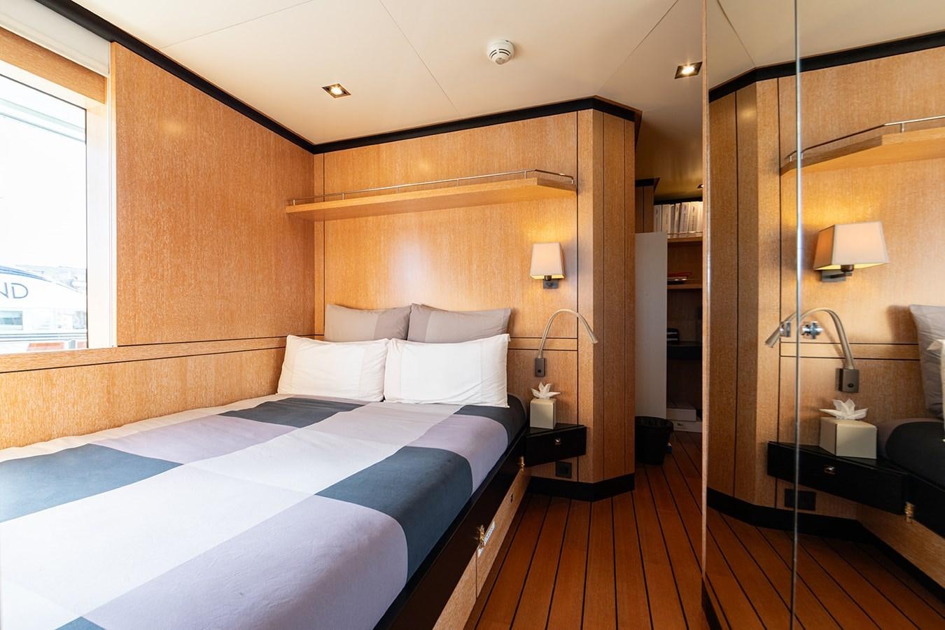 a room with a bed and a mirror aboard BELONGERS Yacht for Sale