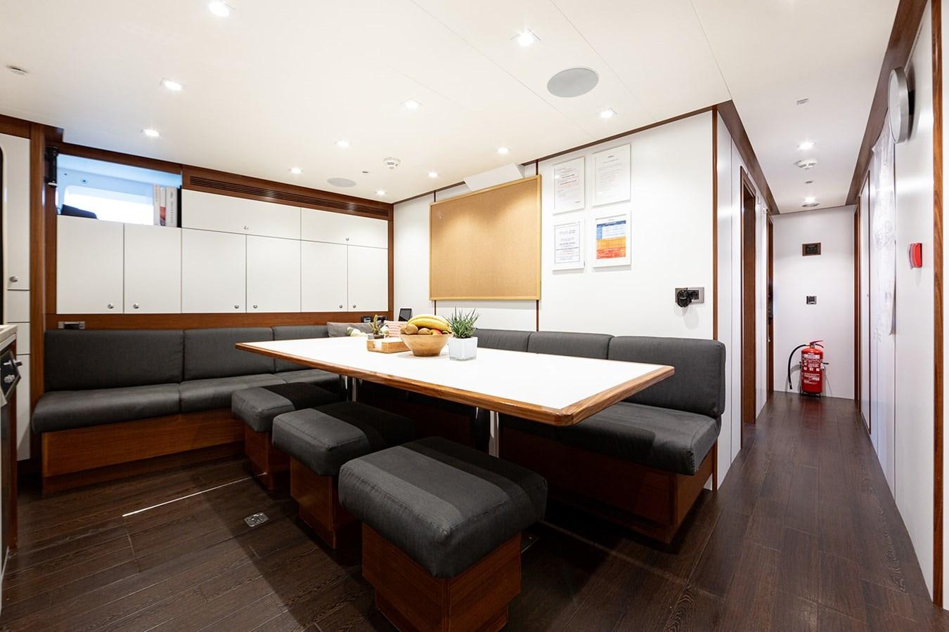 a room with a table and couch aboard BELONGERS Yacht for Sale