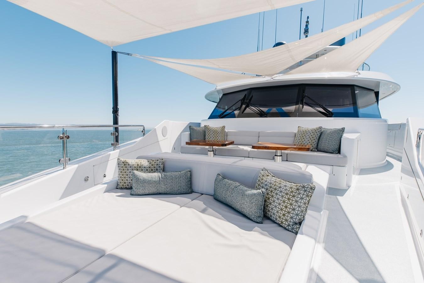 a large white lounge chair on a white deck overlooking a body of water aboard FIGARO Yacht for Sale
