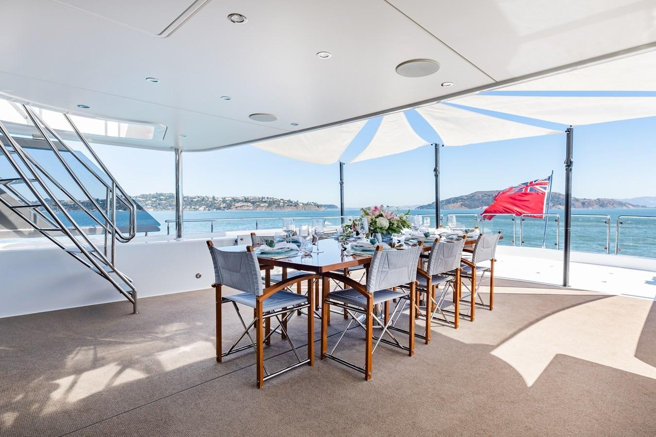 a table and chairs under an umbrella aboard FIGARO Yacht for Sale