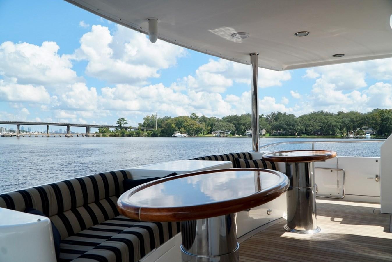 a table on a deck overlooking a body of water aboard MISS PATTI Yacht for Sale