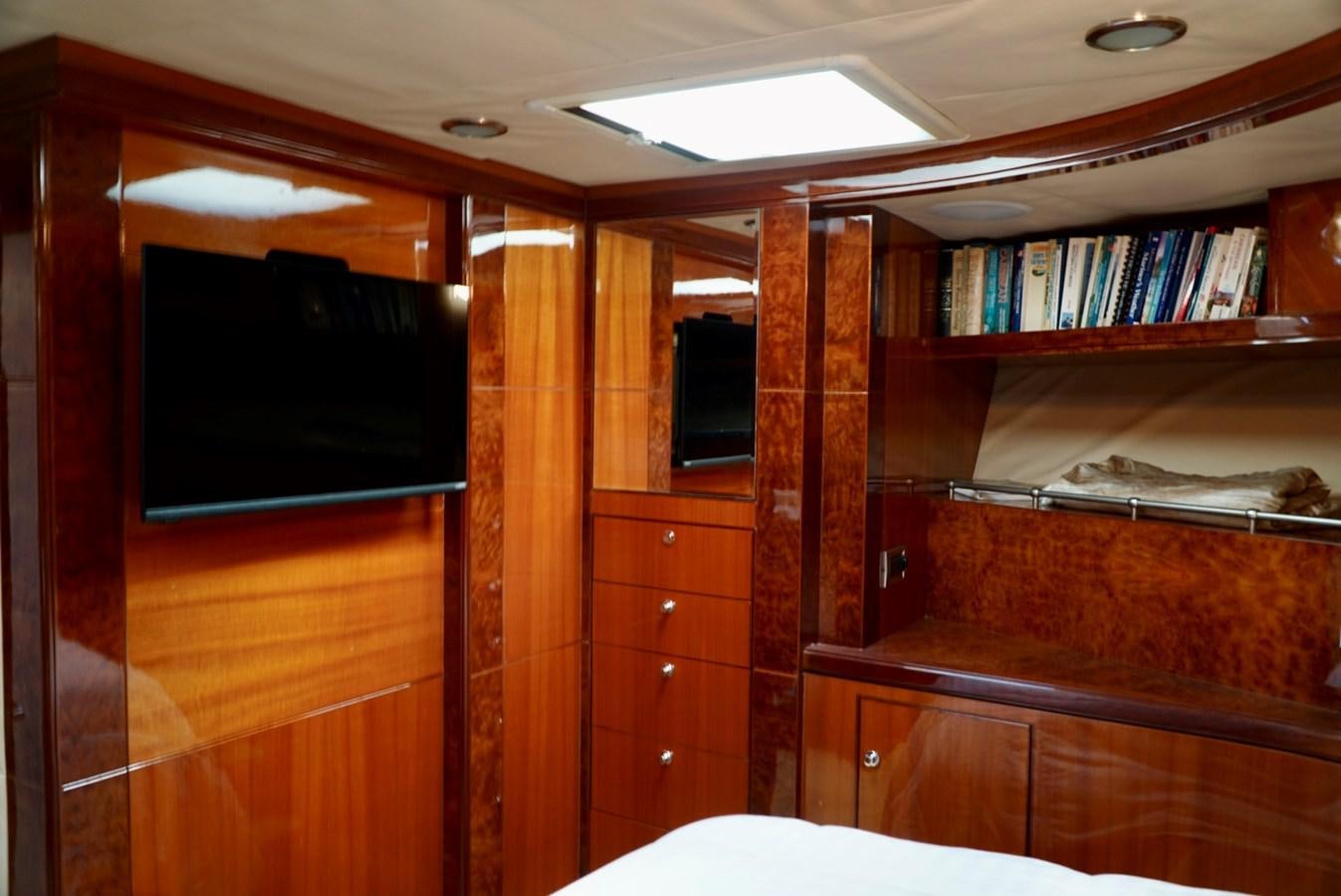 a room with a tv and bookshelves aboard MISS PATTI Yacht for Sale