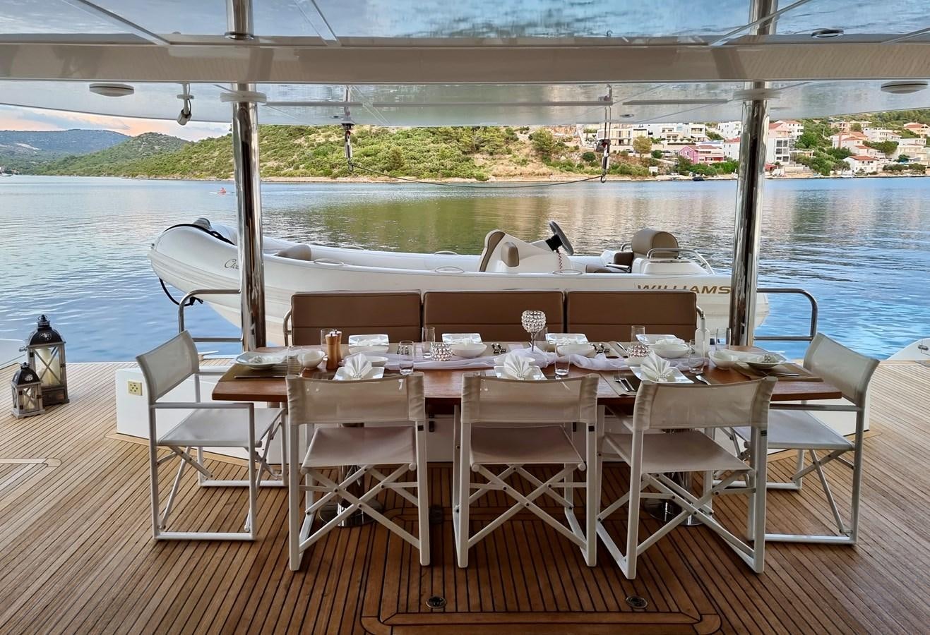 a table set for a dinner on a deck aboard CLOUDS Yacht for Sale