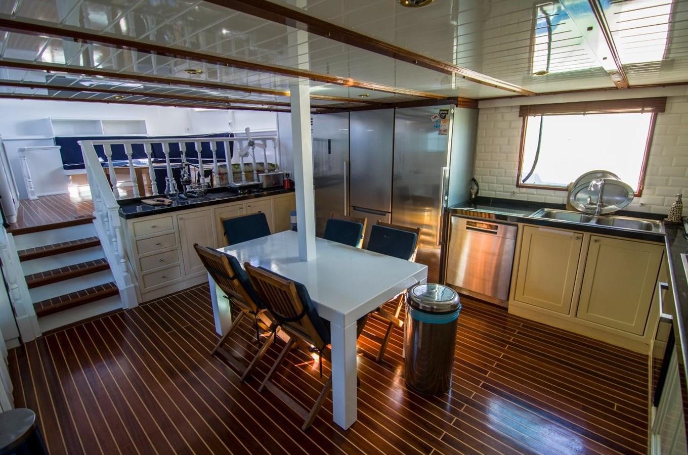 a kitchen with a table and chairs aboard HARRY HALLER Yacht for Sale