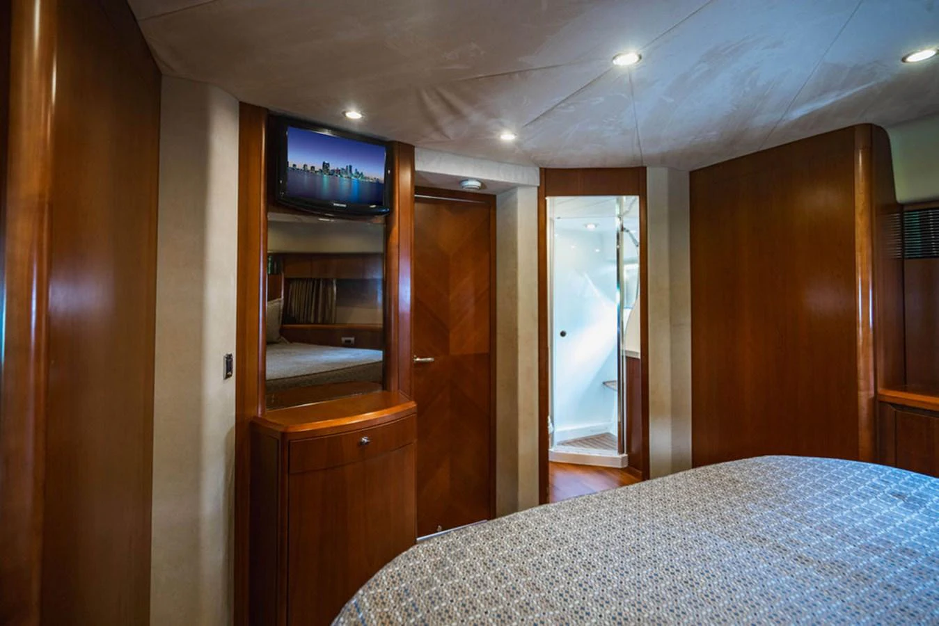 a bedroom with a bed and a television on the wall aboard EMPIRE SUN Yacht for Sale