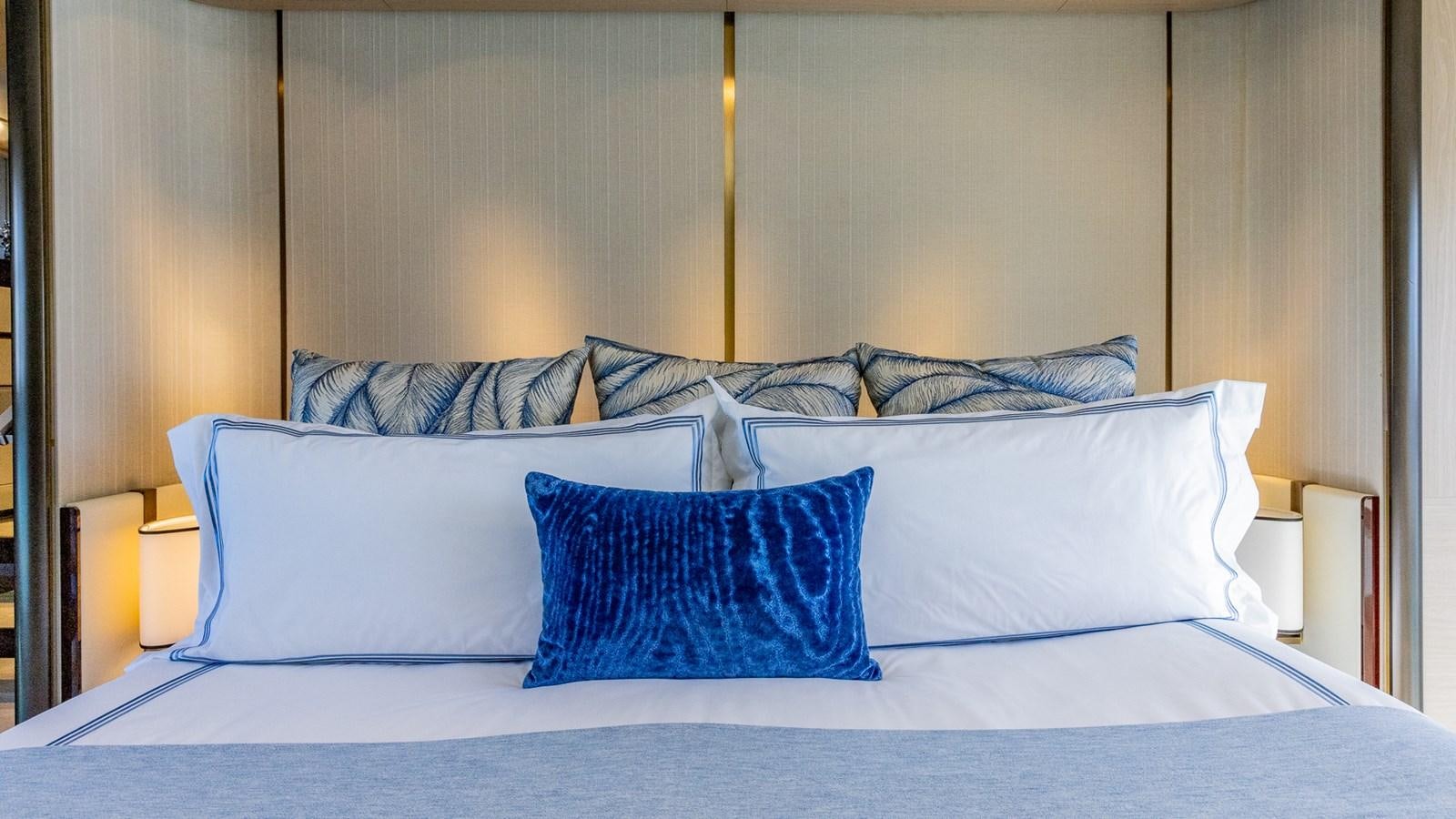 a bed with blue pillows aboard 4 PLAY Yacht for Sale