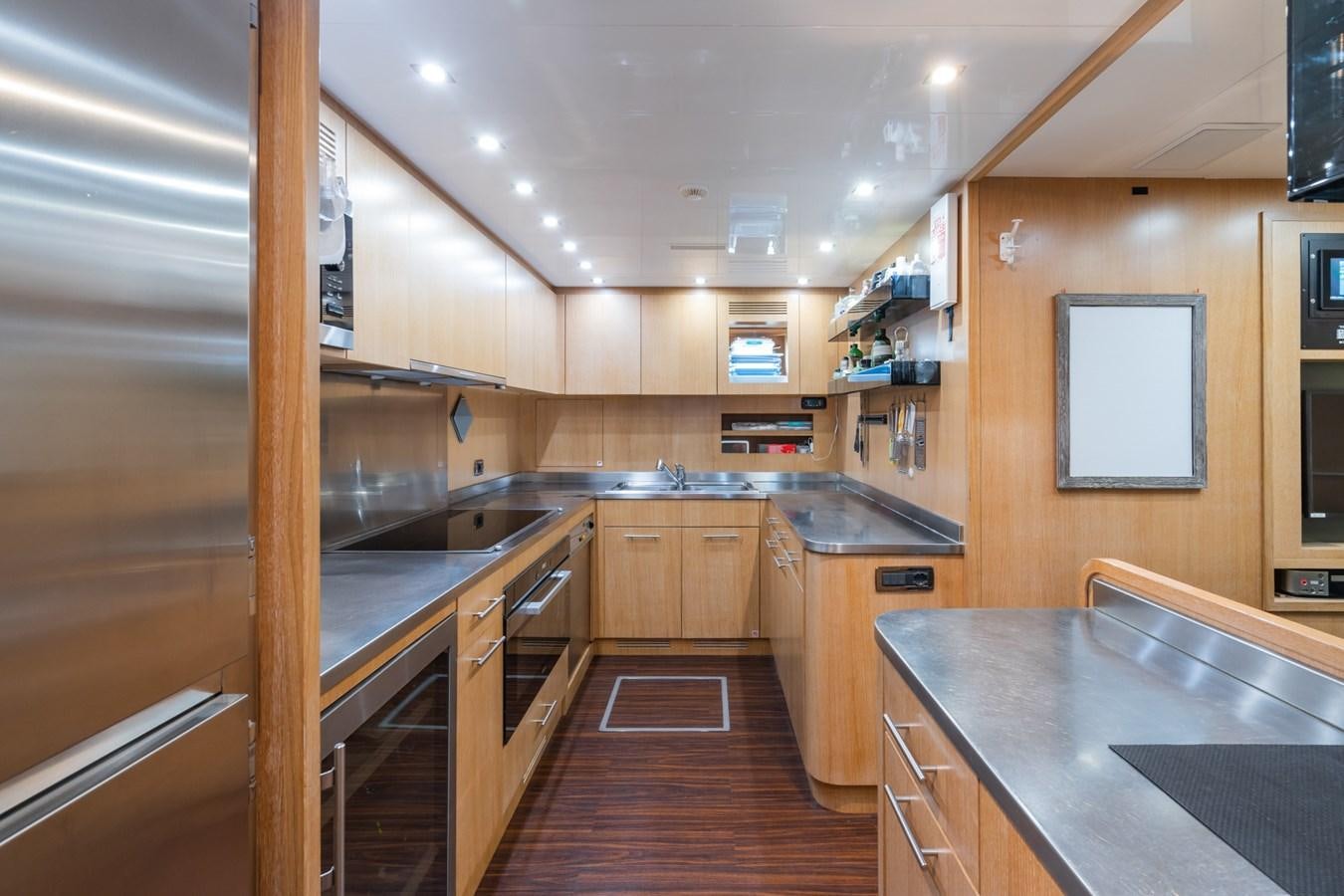 a kitchen with wooden cabinets aboard MANGUSTA MAXI OPEN 108#23 - TECHNOMARINE - CAREFULLY USED Yacht for Sale