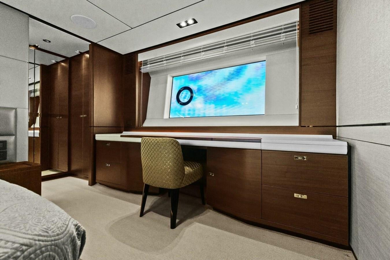 a tv on a stand in a room with wood cabinets and a bed aboard AMARULA SUN Yacht for Sale