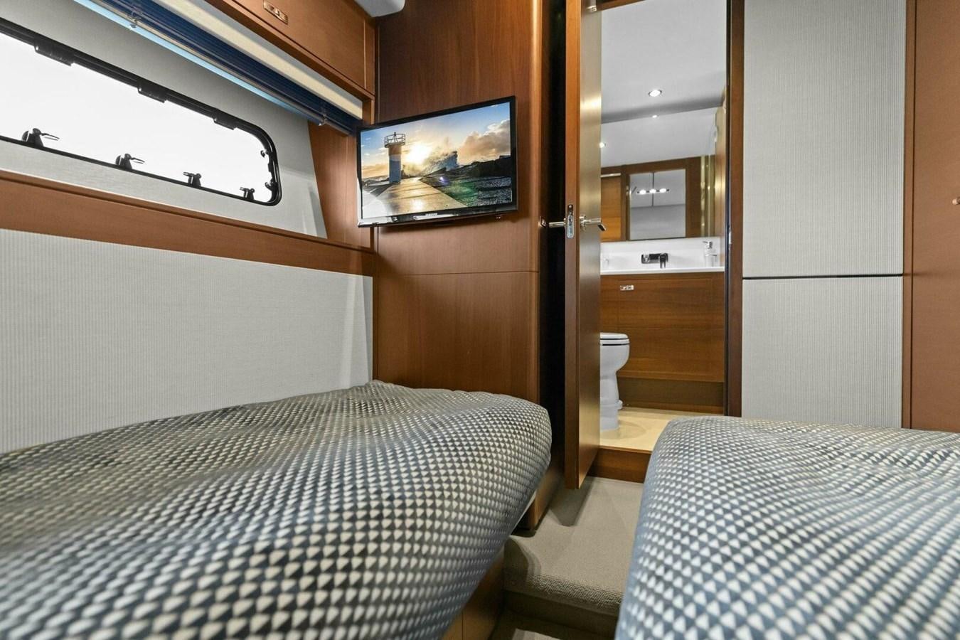 a bedroom with a tv on the wall aboard AMARULA SUN Yacht for Sale