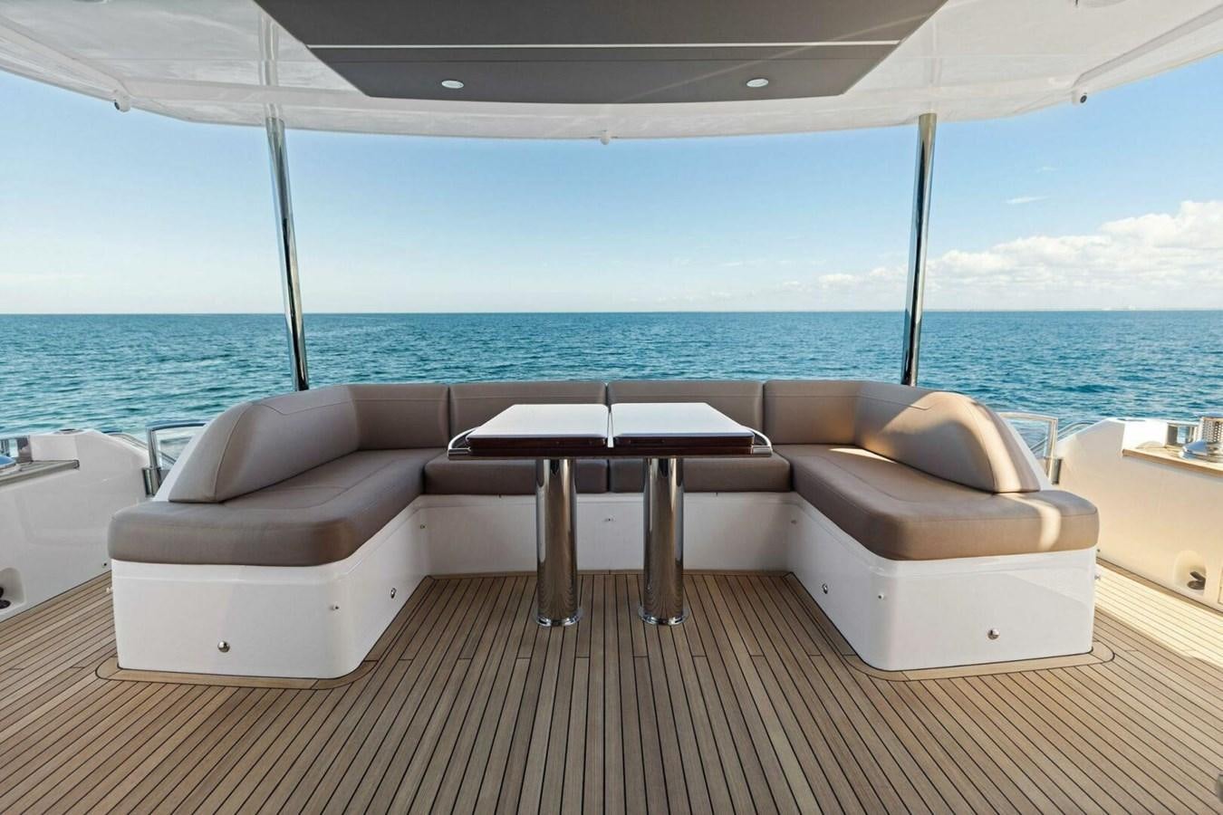 a couch and a table on a deck overlooking the ocean aboard AMARULA SUN Yacht for Sale
