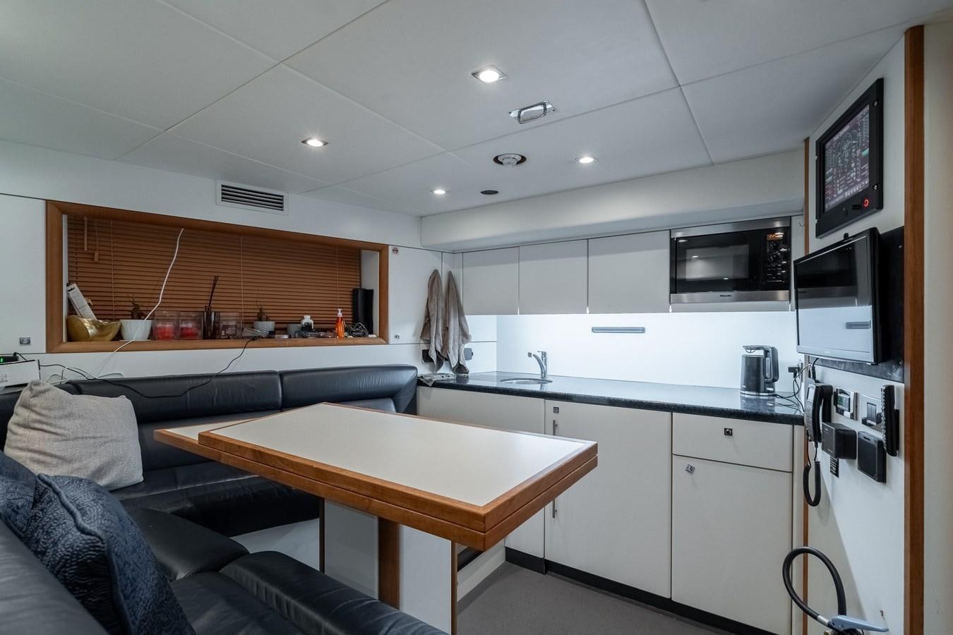 a kitchen with a table and a couch aboard SUNSEEKER PREDATOR 115 Yacht for Sale