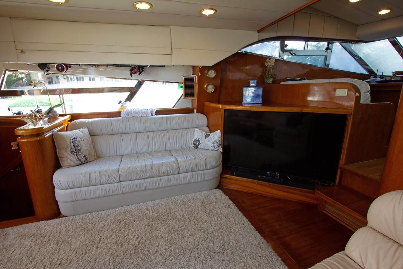 a living room with a couch and a television aboard MADNESS Yacht for Sale