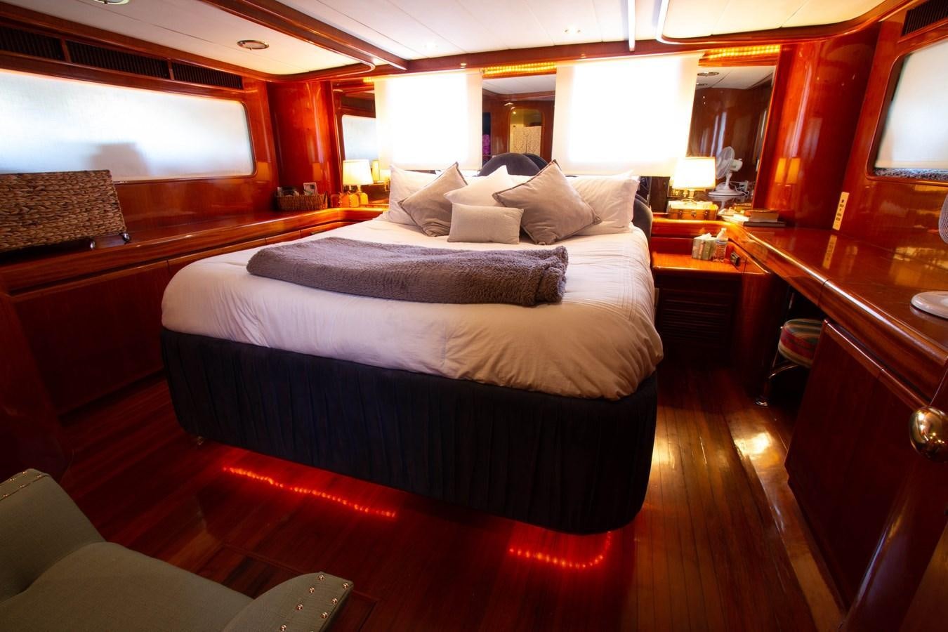 a room with a bed and desk aboard MADNESS Yacht for Sale