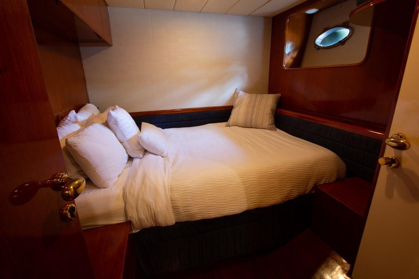 a bed with white sheets aboard MADNESS Yacht for Sale