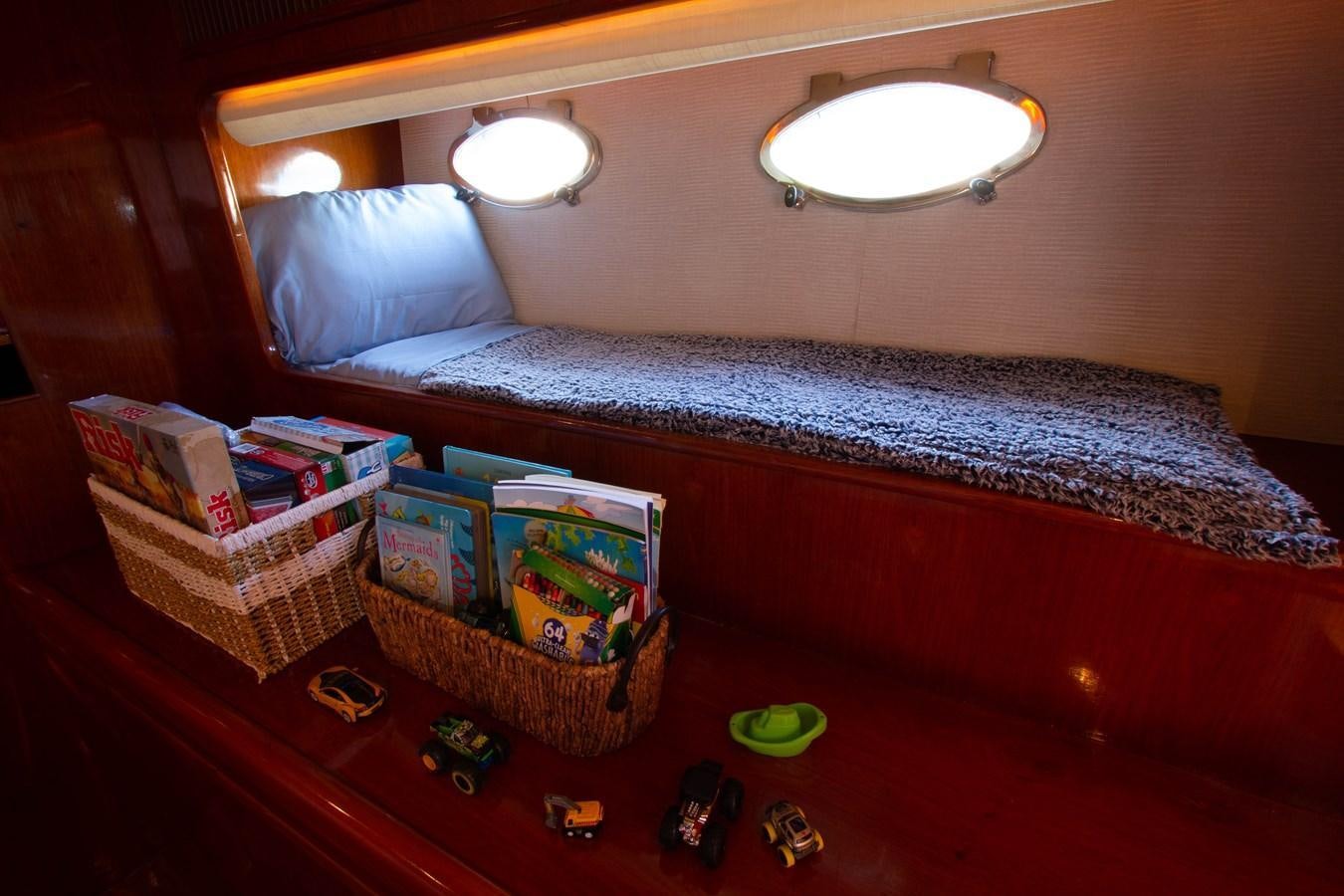 a bed with a basket and toys aboard MADNESS Yacht for Sale