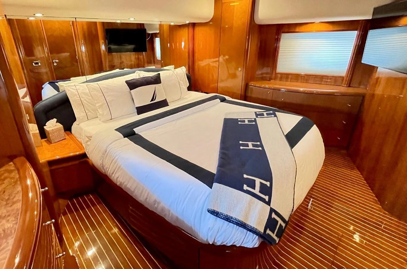 a bed with a blue and white sheet on it aboard AZIMUT 100/32 Yacht for Sale