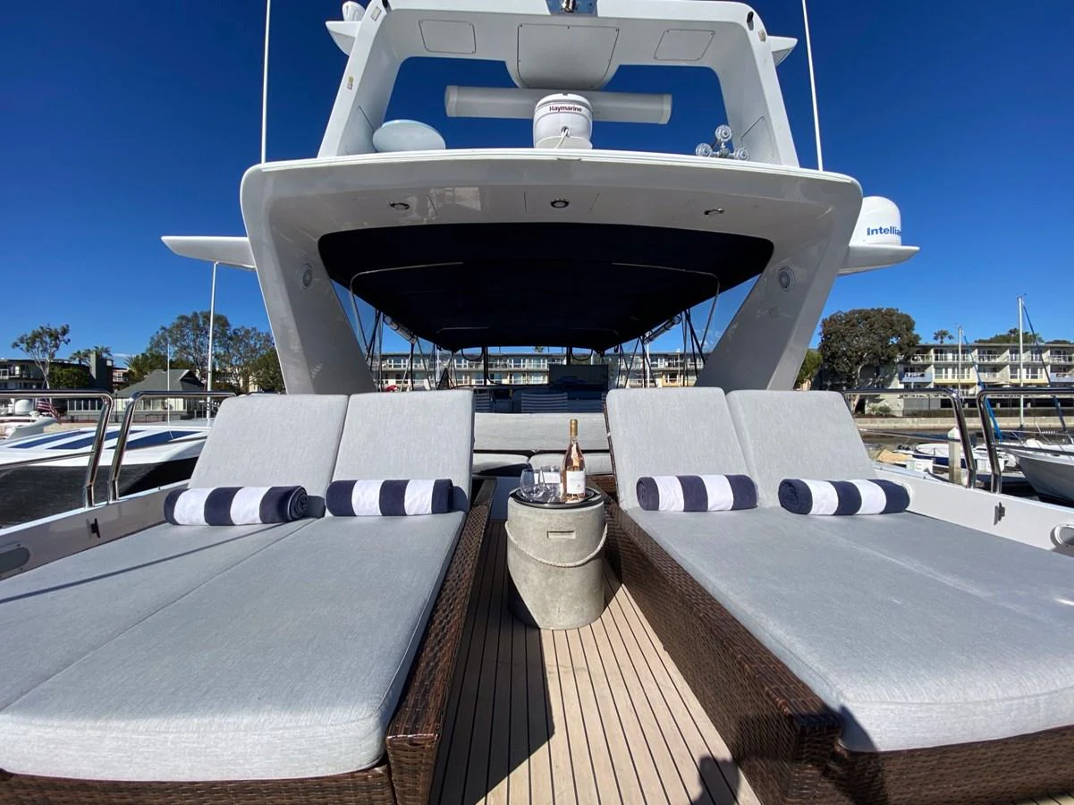 a large white boat with a deck and a deck with chairs and a table with a bottle on aboard AZIMUT 100/32 Yacht for Sale