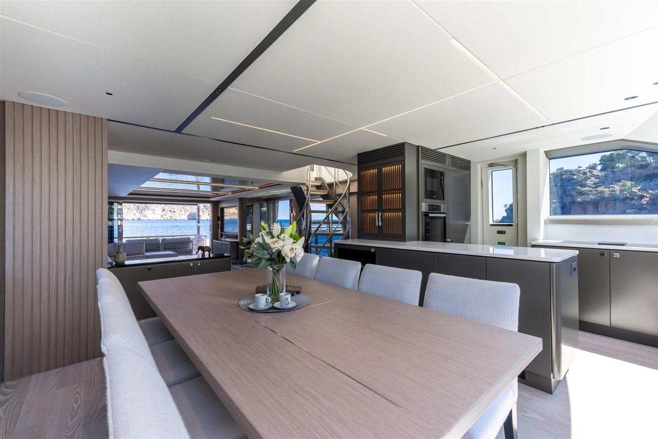 a large room with a table and chairs aboard OCEAN 182 Yacht for Sale